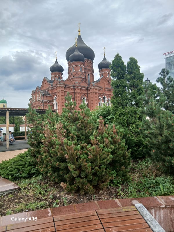 Red brick cathedral, carousel, and fountain plaza in a Russian city