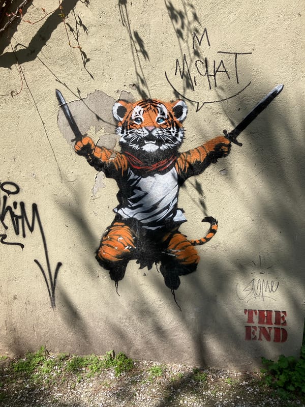 Street mural shows tiger with swords on concrete wall