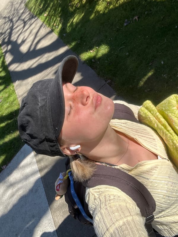 Woman rests on Vancouver sidewalk in evening sunlight