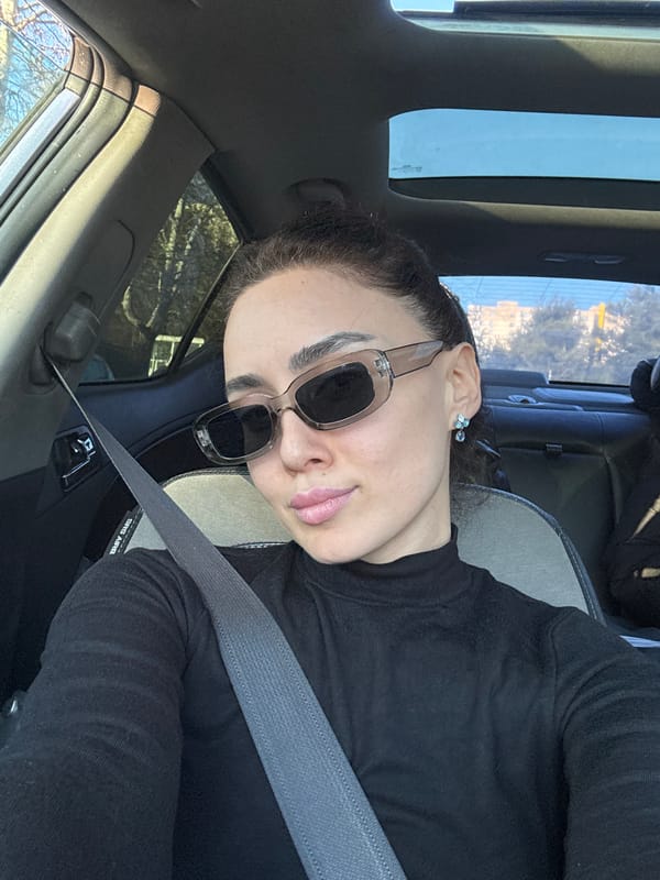 Woman takes selfies in car passenger seat in Tbilisi