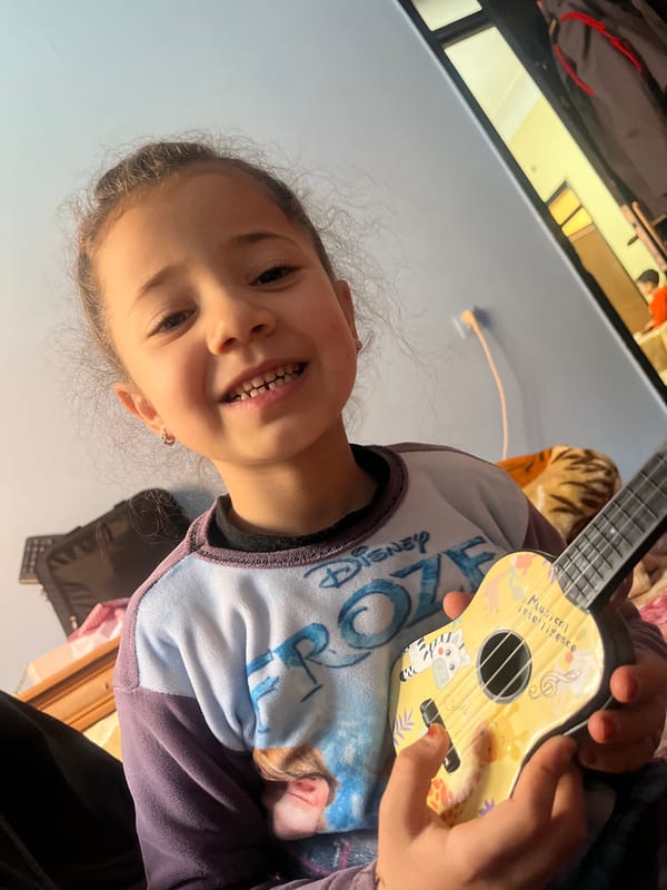 Young girl poses with toy ukulele in Morocco