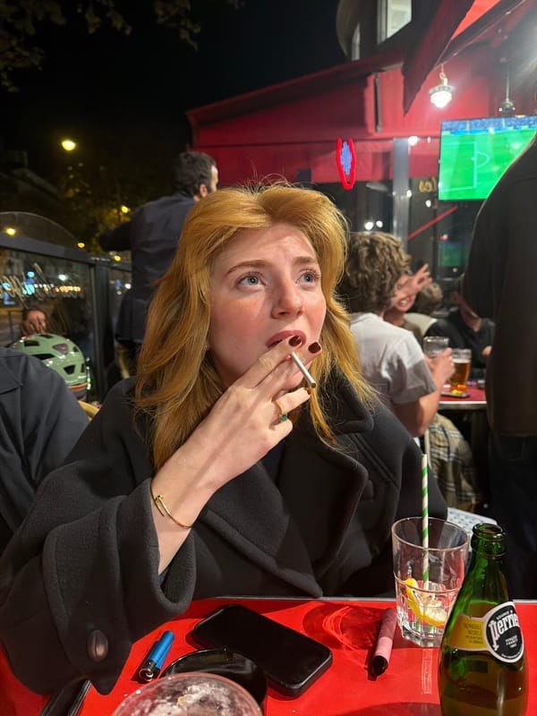 Woman sits at outdoor Parisian café table