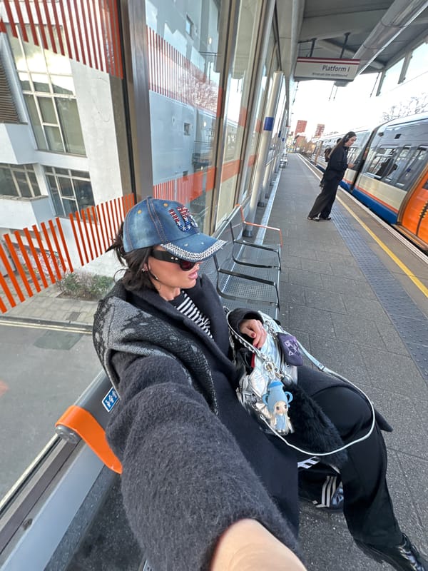 Person with silver handbag waits at London train platform