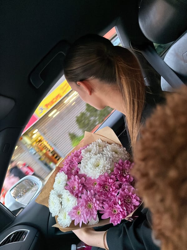 Woman carries flower bouquet in moving car in Sofia