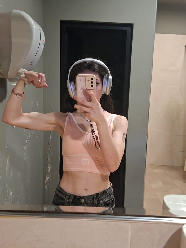 Person with smartphone observed in bathroom wearing pink top