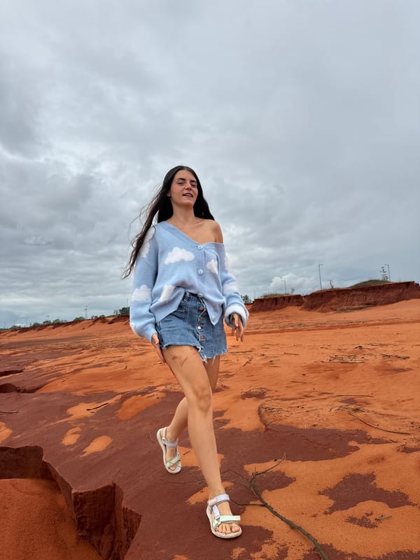 Tourist poses at Fairy Stream red rocks, Mui Ne