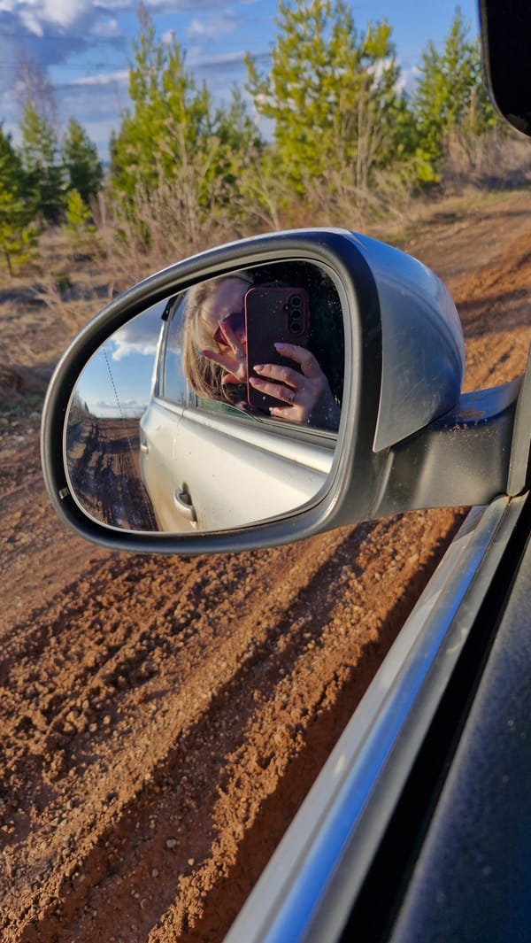 Blonde traveler takes selfies while driving rural Russian road