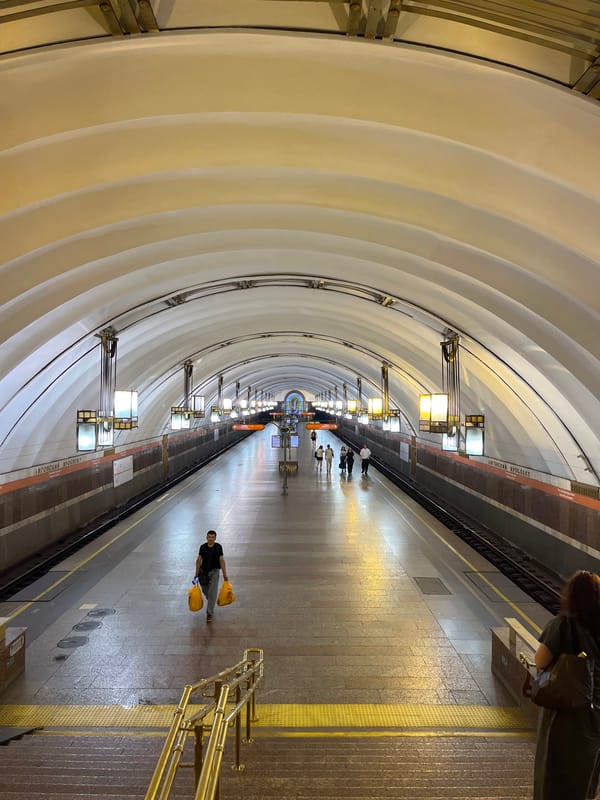 Inside Pushkinskaya metro station's vaulted, illuminated platform.