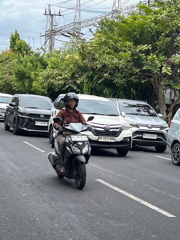 Morning scooter traffic flows through Denpasar streets