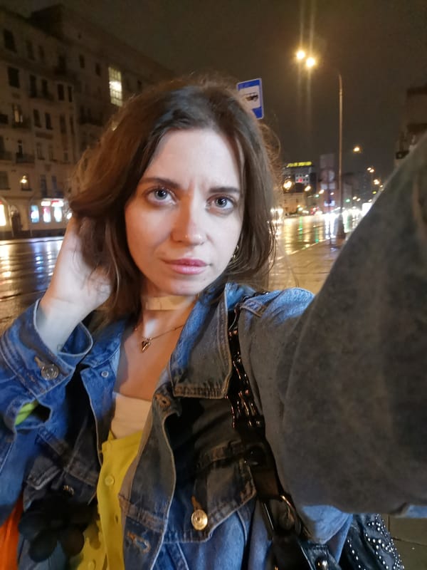 Woman Takes Nighttime Selfies on Wet City Street