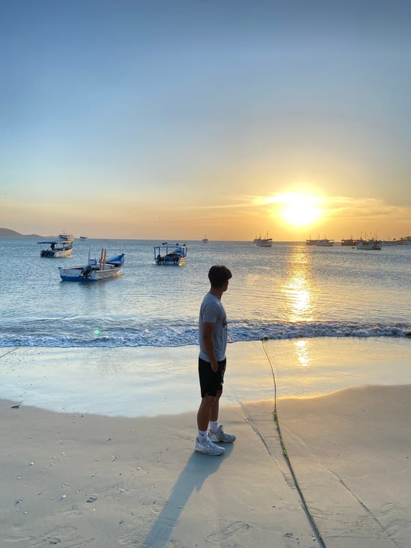 Man watches sunset from Juan Griego beach, Venezuela