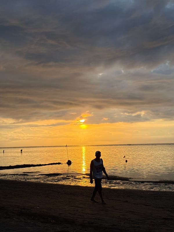 Evening beach gathering documented during sunset in Buleleng, Indonesia