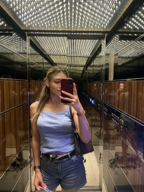 Woman takes elevator selfie, displays French manicured nails