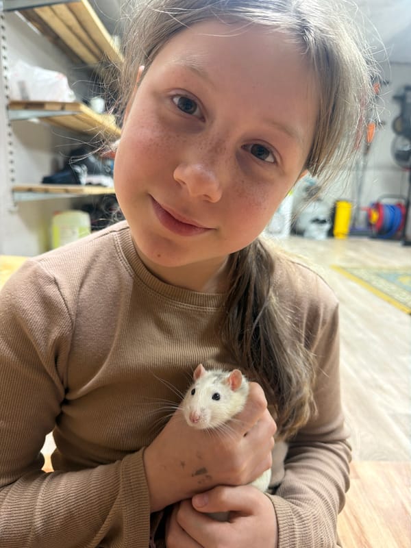 Child and woman play with pet rat in Markovo home