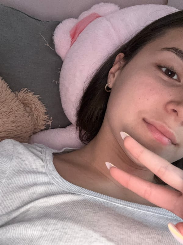 Woman makes peace sign gesture while resting indoors in Bulgaria
