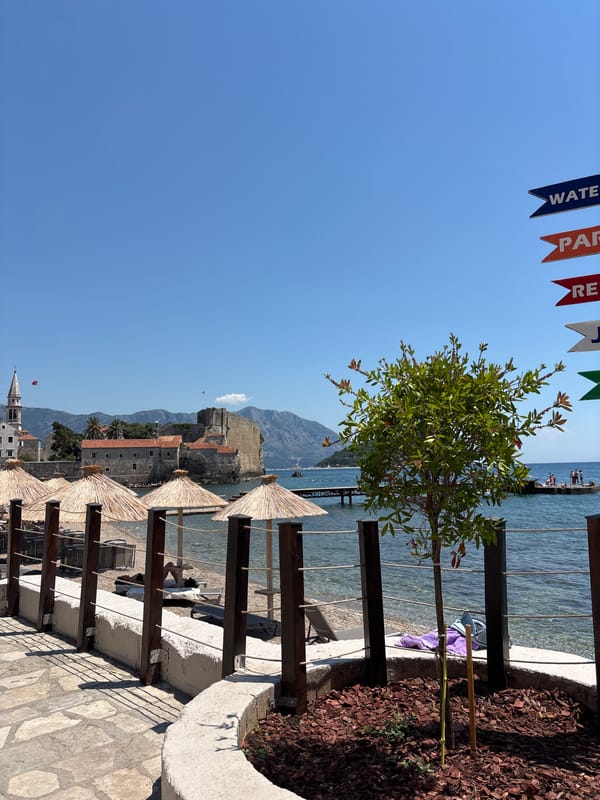 Rocky Mediterranean coastline with beaches, statues, and clifftop paths