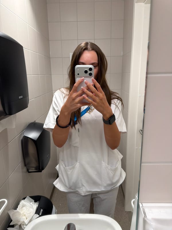 Mirror selfie in white medical scrubs, Harstad bathroom
