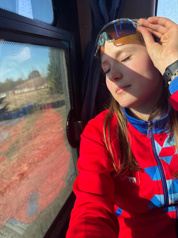 Young person rests in vehicle wearing colorful jacket, Челва