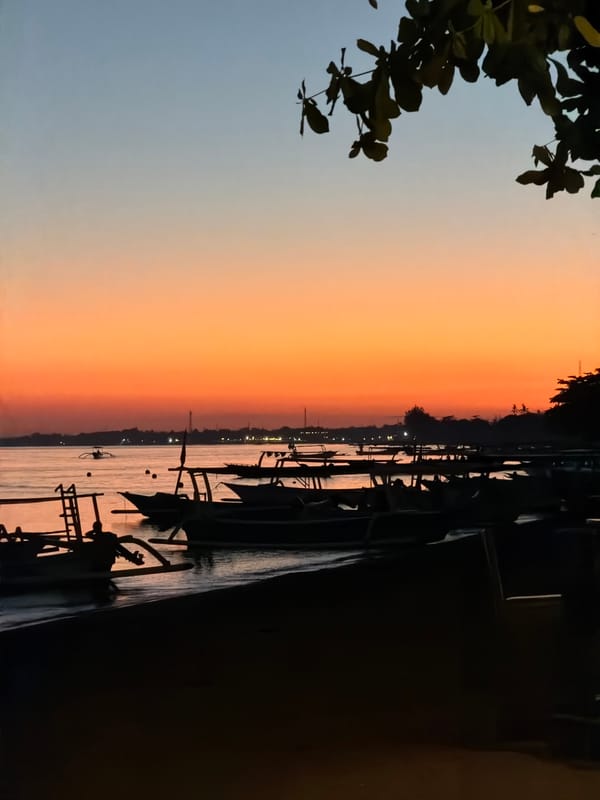 Fishing boats line the Buleleng shore at sunset