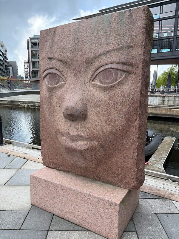 Red granite face sculpture observed in Oslo