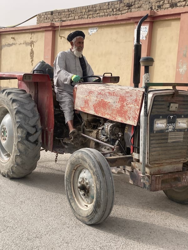 Elderly farmer repairs tractor engine in Quetta, Pakistan