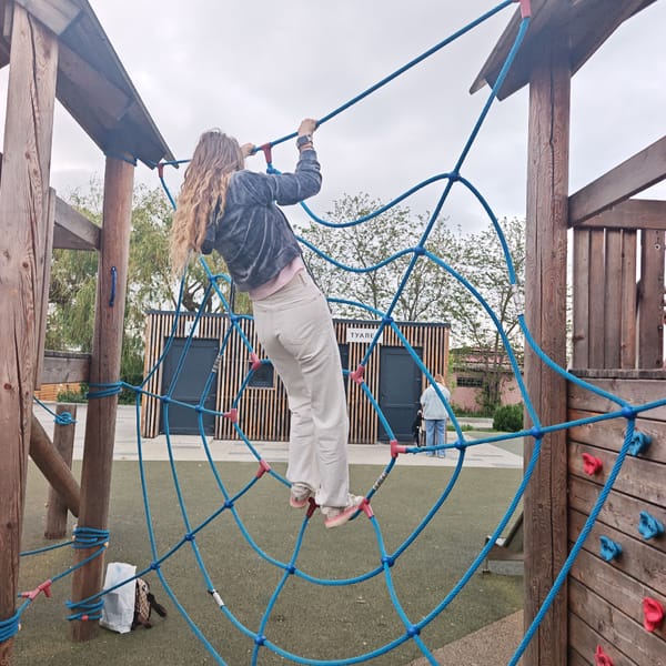 Child climbs rope net at playground
