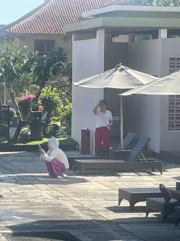 Resort pool day in Kuta Selatan, kids swimming, adults relaxing
