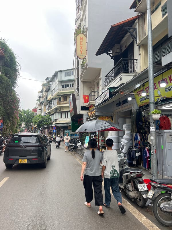 Cyclopousse and market stalls on a Hanoi street