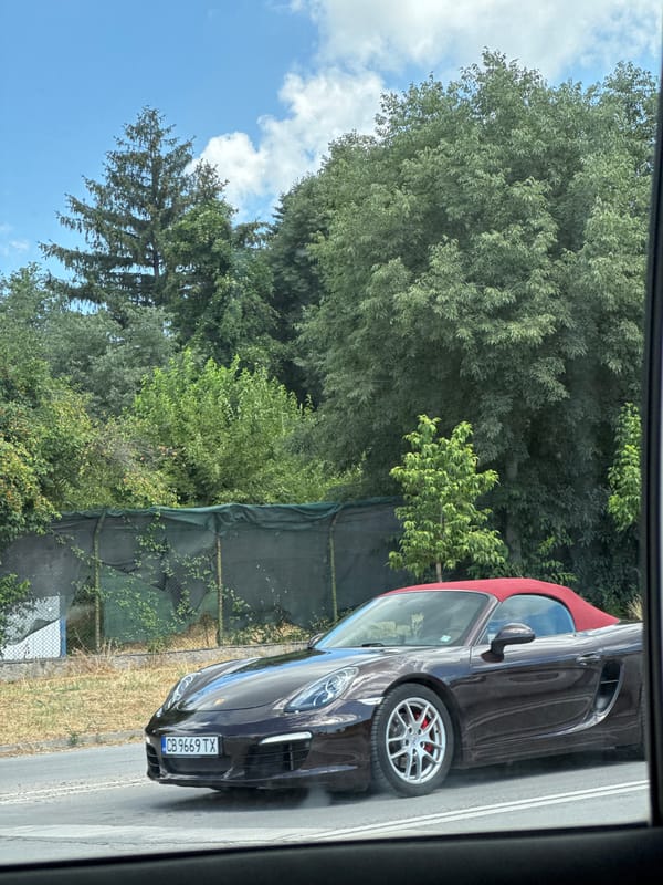 Dark brown Porsche Boxster with red top cruising through Varna