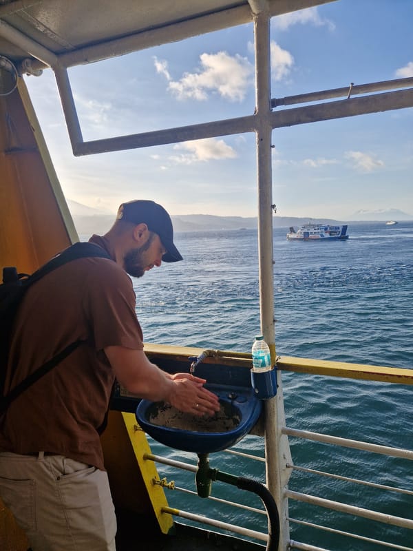 Ferry passengers document morning journey near Melaya, Indonesia coastline