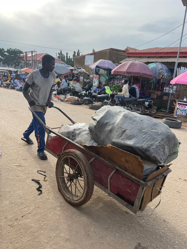 Abuja street market buzzing with vendors, carts, and trade