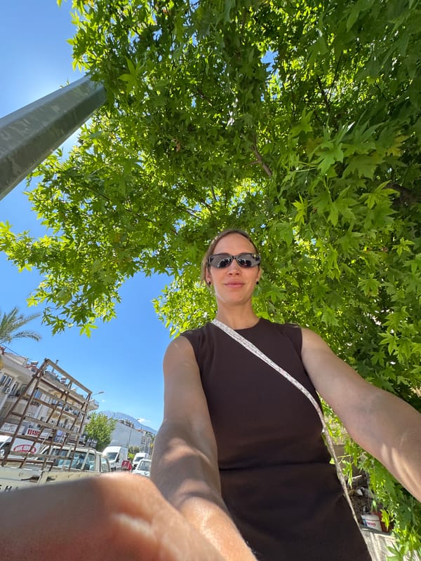 Woman takes selfie under tree in Fethiye, Turkey