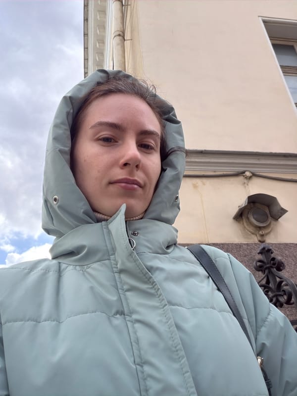 Woman photographed on overcast Saint Petersburg street amid traditional architecture