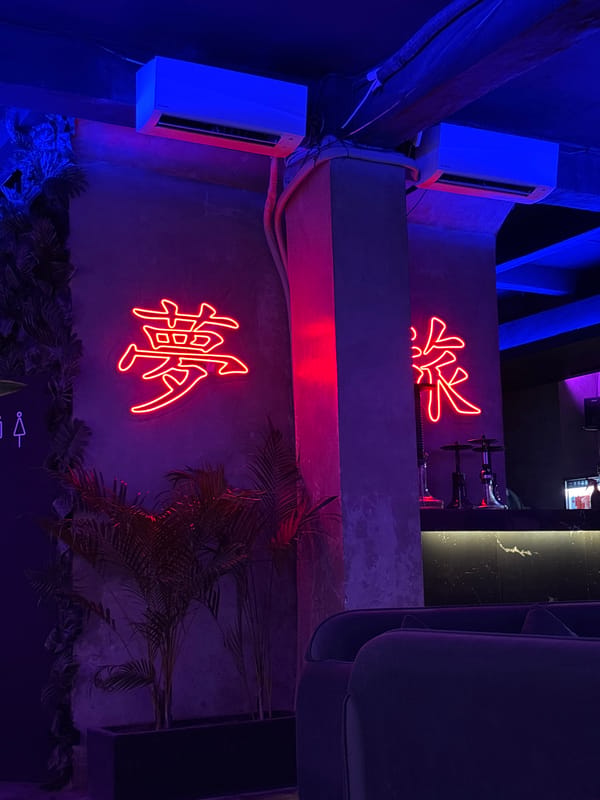 Bar patron documents neon-lit lounge with hookah in Kuta Selatan