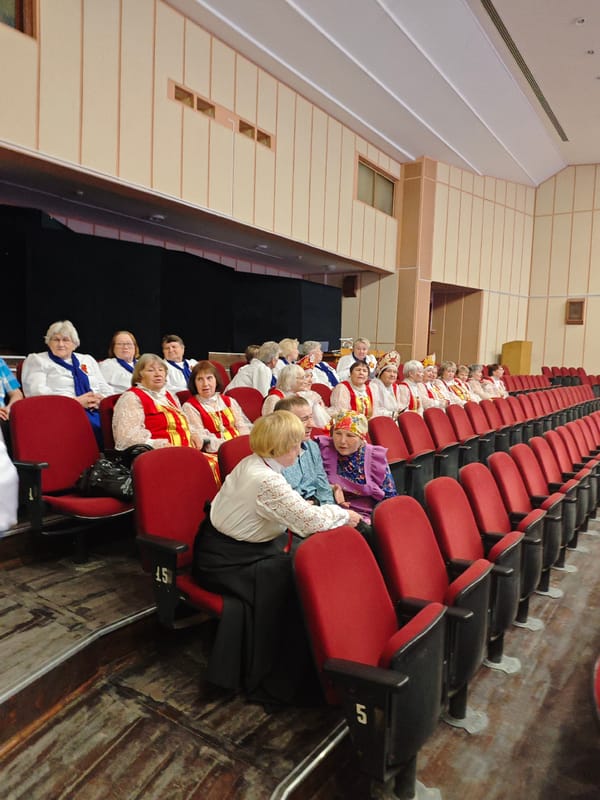Women in traditional Russian folk costumes gather in Markovskii auditorium