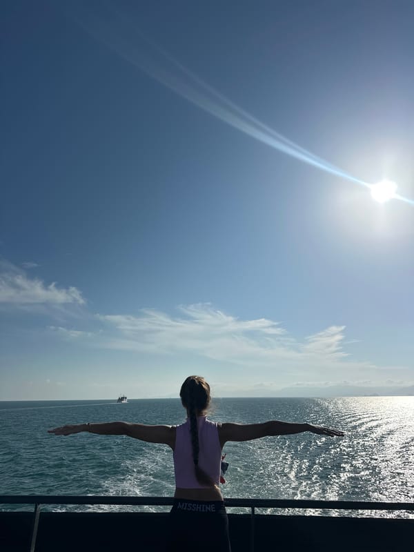 Arms wide on a sun-drenched ferry deck, Gulf of Thailand