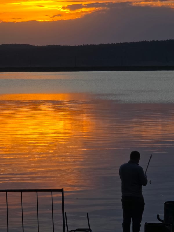 Sunset watchers gather along Chaikovsky waterfront during golden hour