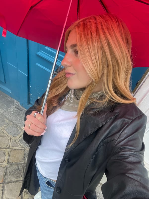 Person with red umbrella spotted at blue door in Paris