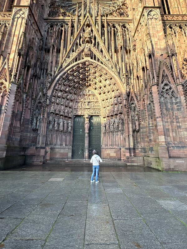 Tourist documents Strasbourg Cathedral during rainy evening visit