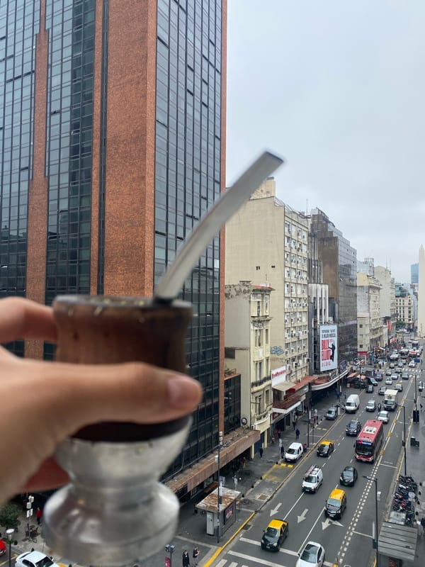 Person enjoys traditional mate with Buenos Aires cityscape view