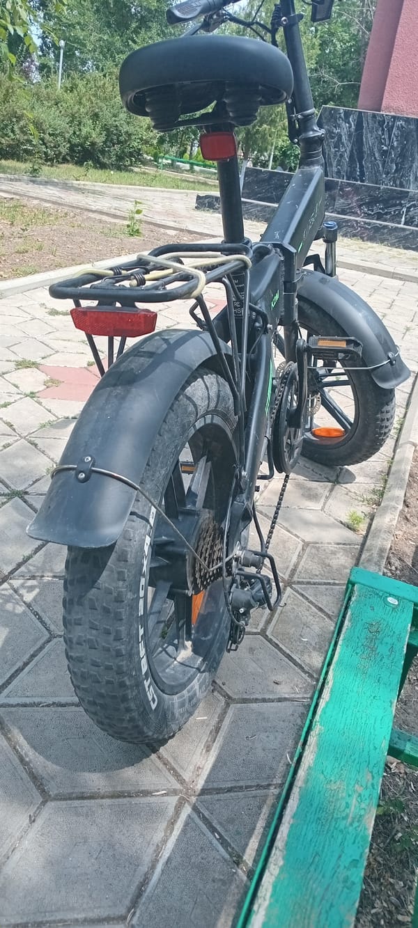 Fat-tire electric bike parked on gray pavement outdoors