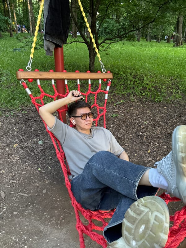 Man relaxes in red hammock at Moscow park