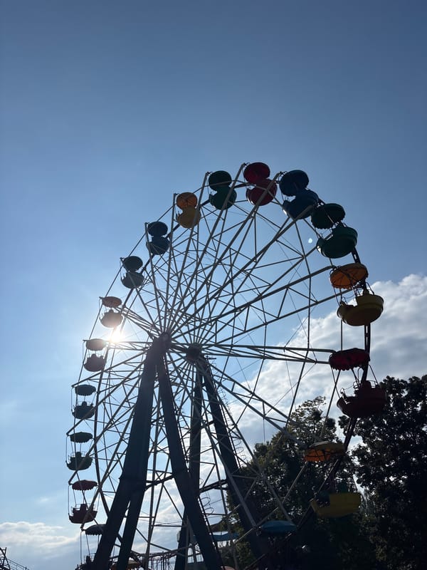 Morning at a fairground park, flowers and rides in the sun