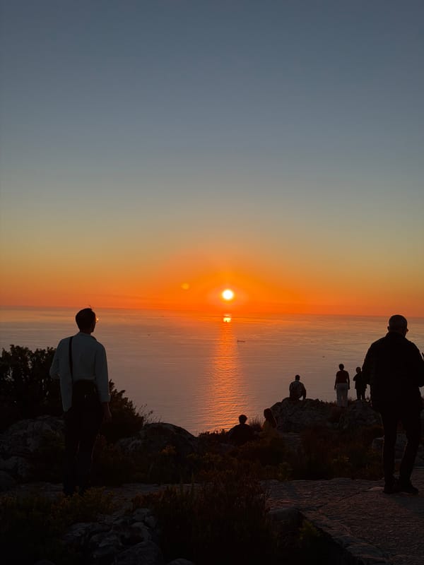 Cape Town coastal sunset draws observers to rocky outcrops