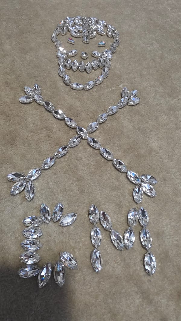Person arranges rhinestone letters on fabric in Bulgaria