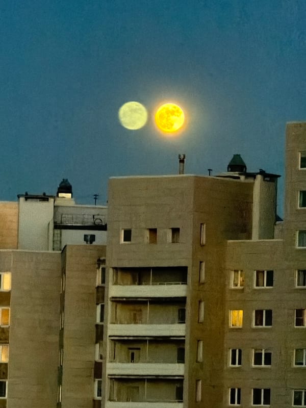 Moon rises beside residential building in Murino, Russia
