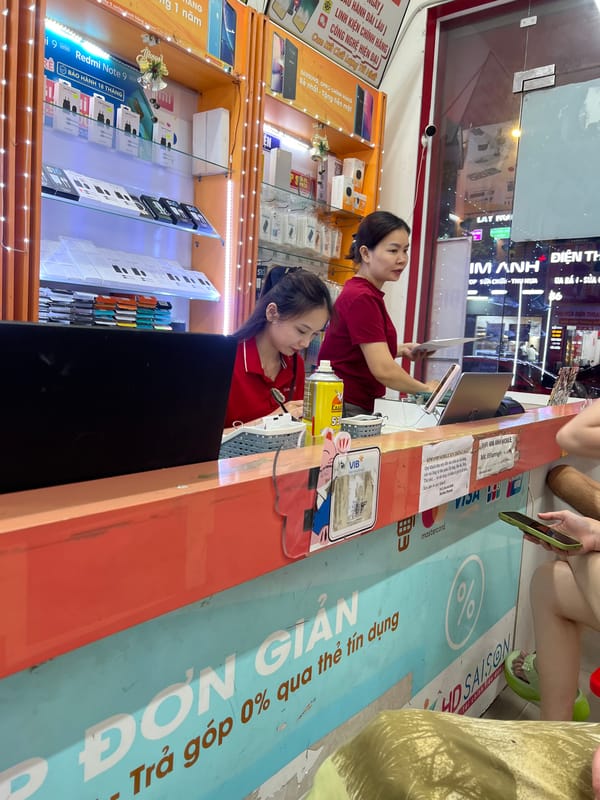 Inside a Da Nang mobile phone shop, staff at the counter