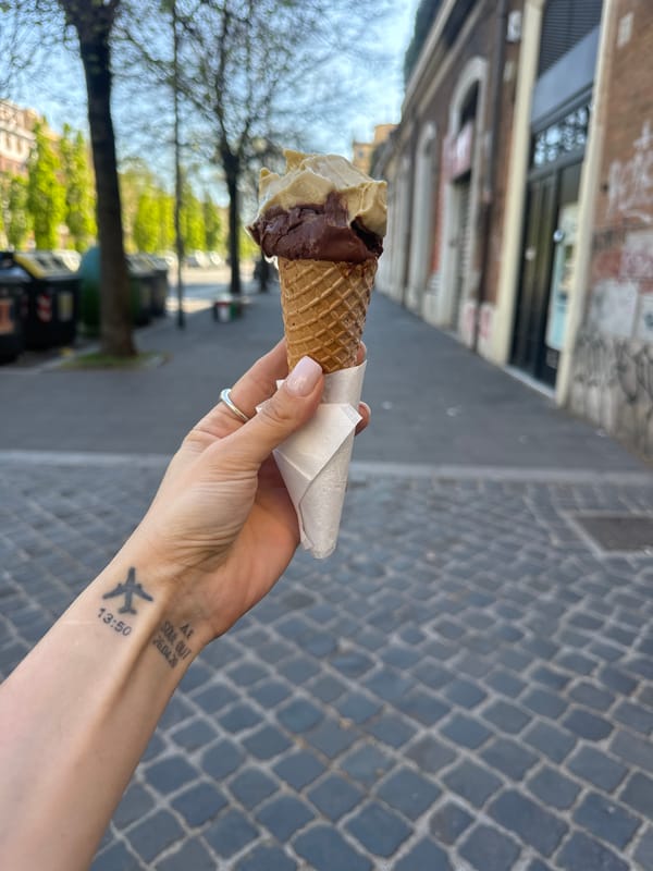 Woman enjoys gelato on cobblestone street in Rome