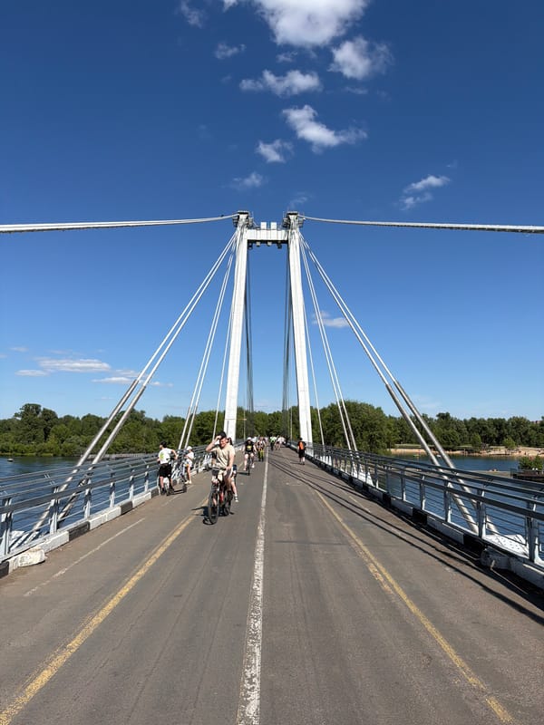 Morning activity along Krasnoyarsk's Strelka Bridge and riverside park