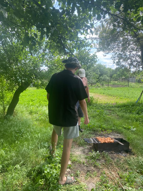 Rural Ukraine BBQ gathering features grilled fish under dramatic skies